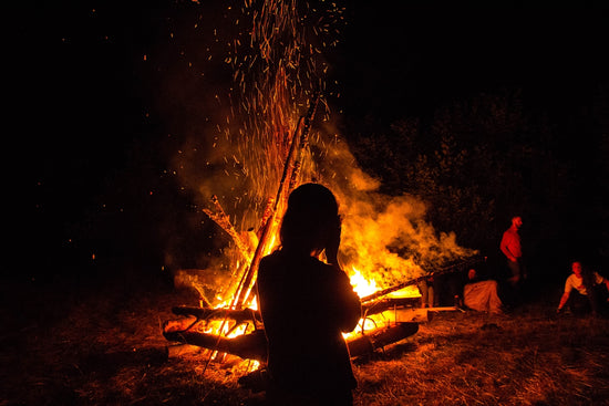 silhouette of person facing bonfire