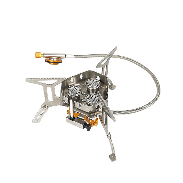 A compact, foldable camping stove with three burners and silver stainless steel construction is shown against a white background. A flexible gas line is attached to the side.