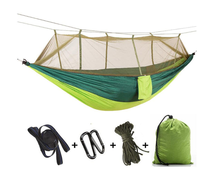 A two-tone green and yellow ultralight parachute hammock with a deployed mosquito net, along with its included black tree straps, silver carabiners, green rope, and a green stuff sack.