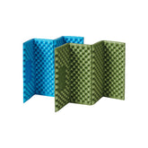 Two folded egg nest cushions, one blue and one green, are shown partially unfolded to reveal their textured surface. The blue cushion is angled to the left, and the green cushion is angled to the right. Below are icons illustrating "Soft elastic comfort," "Lightweight and portable," "Durable," and "Waterproof and moisture-proof."