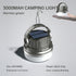 A round, silver and white camping lantern with a black solar panel on top and a silver hanging hook extended. Text above the lantern reads "3000MAH CAMPING LIGHT" and "Hermes green". Smaller text below indicates size, endurance, weight, and dimming modes. A hand holding a smaller version of the same lantern is visible in the upper right corner.