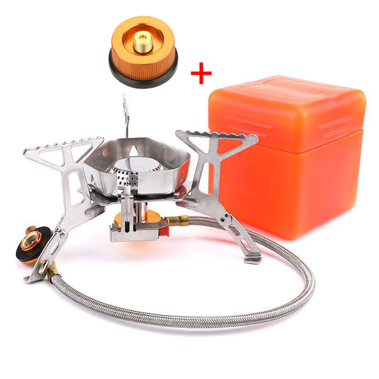 A silver stainless steel camping stove with a flexible hose and a brass connector is shown next to an orange plastic carrying case on a white background. The stove has three foldable pot supports and a central burner.