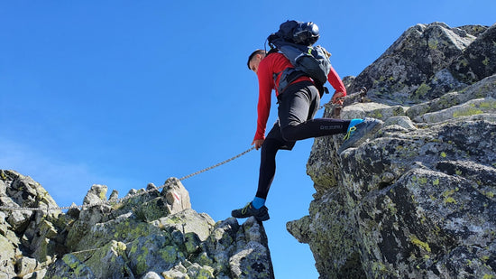 a man climbing up the side of a mountain