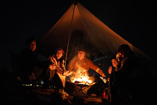 a group of people sitting around a campfire