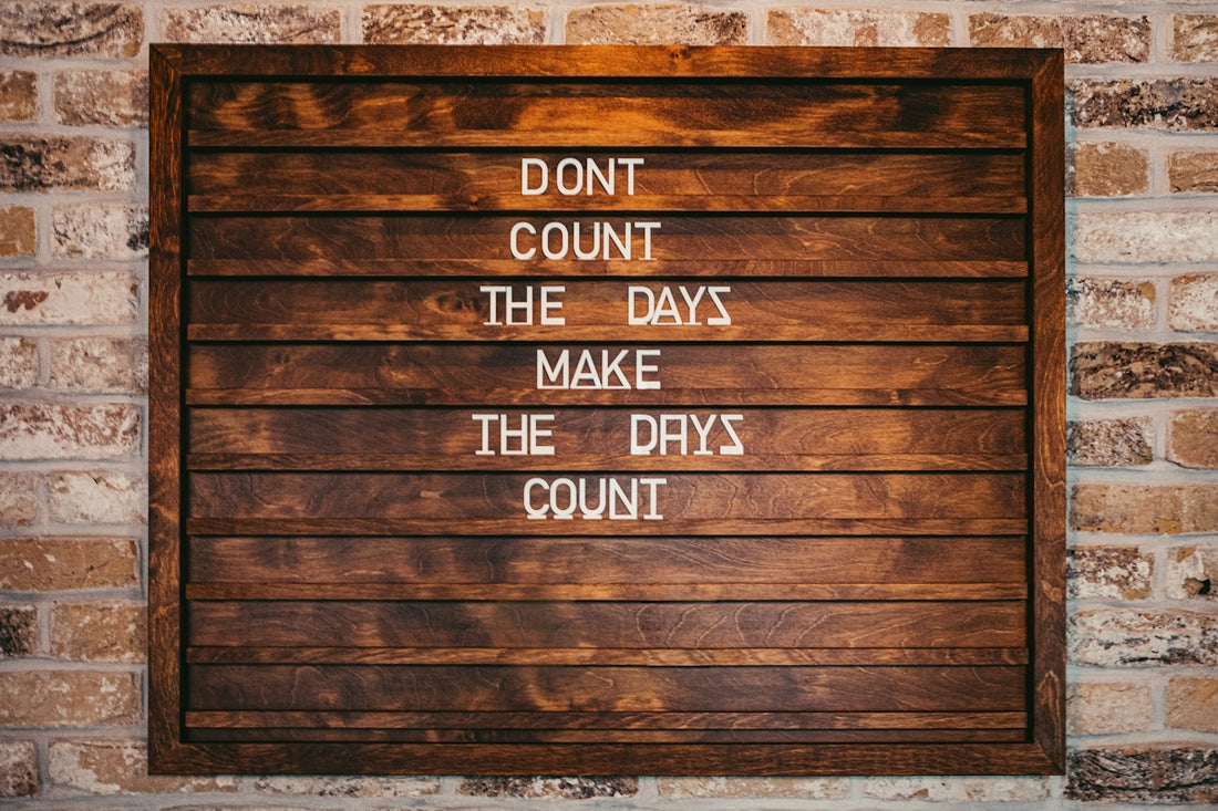 a wooden sign that says don't count the days make the days count