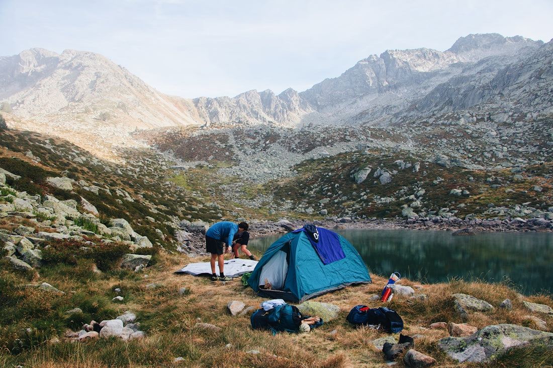 a man in a tent with a mountain in the background