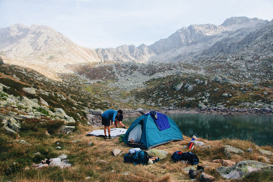a man in a tent with a mountain in the background