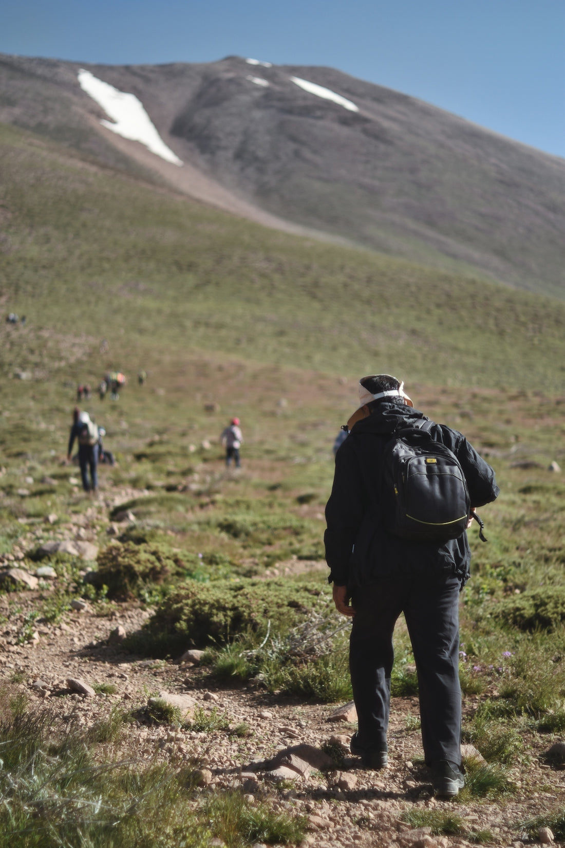a man with a backpack walking up a hill