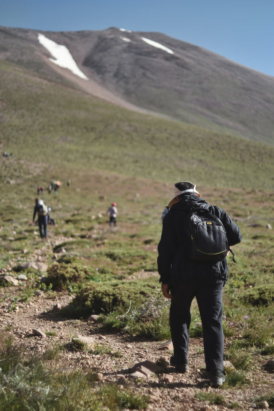 a man with a backpack walking up a hill