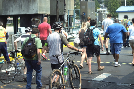A group of people crossing a street with bicycles