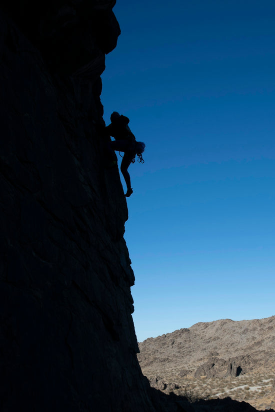A man climbing up the side of a mountain