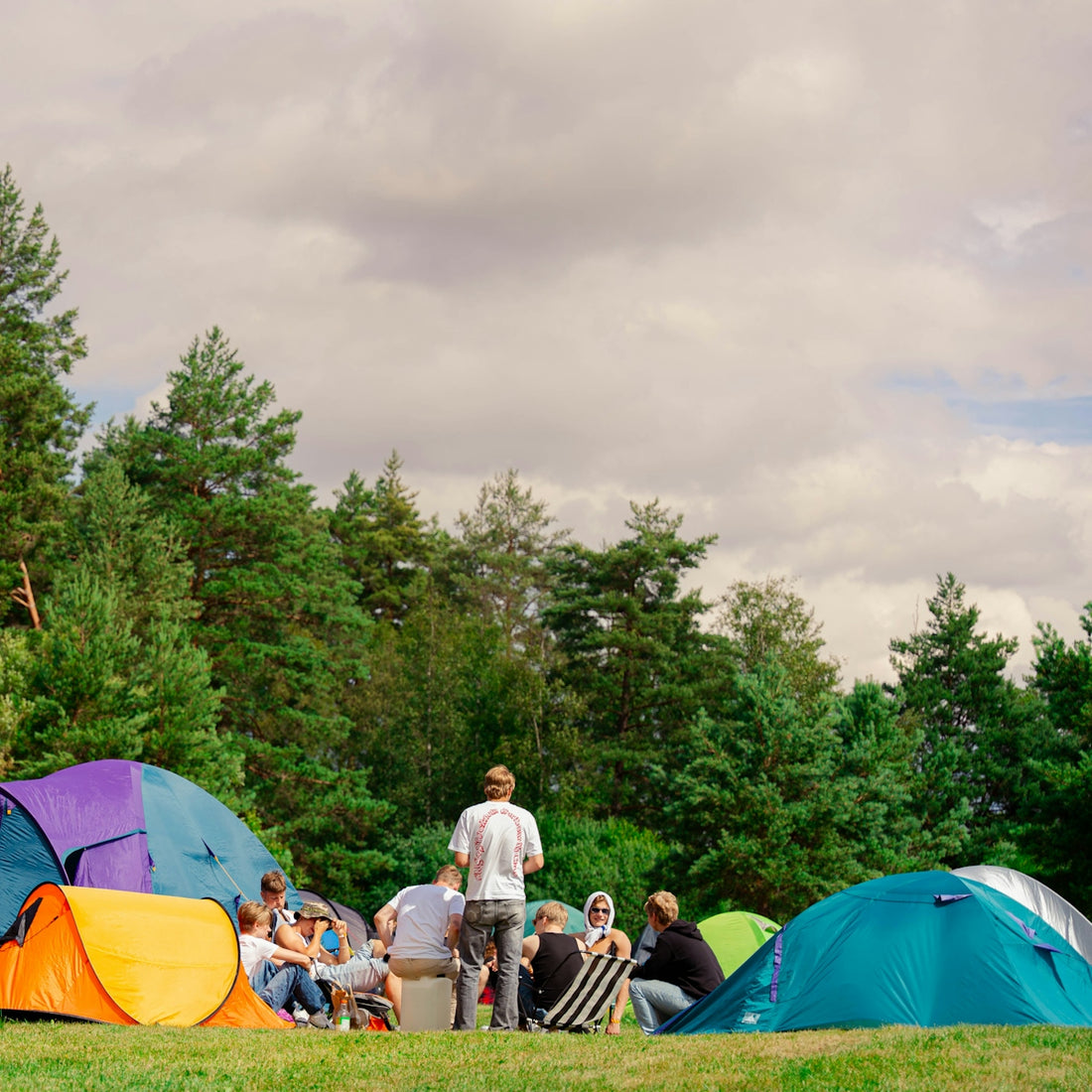 People are camping outside, gathered in a circle.