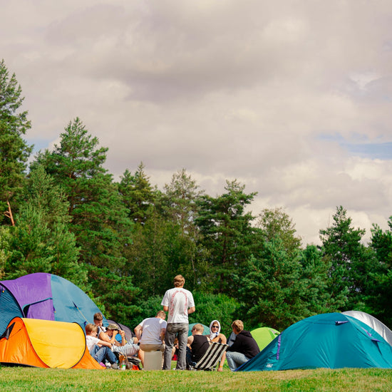People are camping outside, gathered in a circle.
