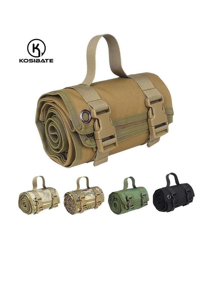  A tan-colored mat is shown rolled up and secured with two tan nylon straps and brown plastic buckles. A tan carrying handle extends from the top of the rolled mat.