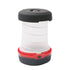 A compact camping lantern with a black top and base, a translucent white collapsible middle section, and a red band with a button is shown against a white background. The lantern is in its collapsed state.