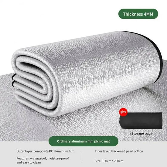 A rolled-up silver picnic mat with a textured surface is shown on a reflective silver surface. A small black storage bag is visible to the right. Text indicates "Thickness 4MM," "Thickened tree pattern moisture-proof pad," "Outer layer: composite PC aluminum film," "Inner layer: thickened pearl cotton," "Features: waterproof, moisture-proof and easy to clean," and "Size: 90cm * 200cm."   

