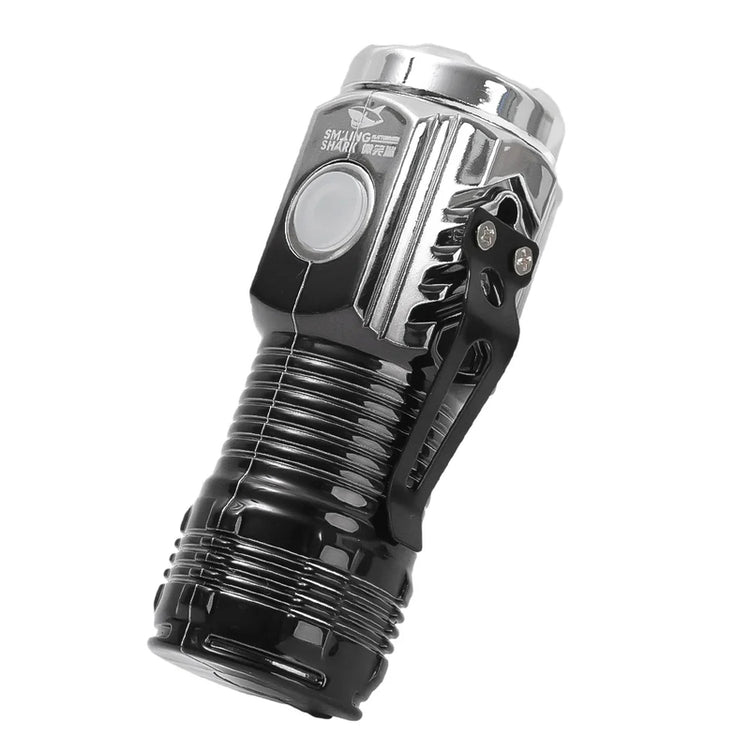A small, black Smiling Shark mini LED flashlight with a metal clip is angled against a white background. A silver power button is visible on the side. Text on the flashlight includes "SMILING SHARK" and Chinese characters