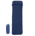An inflated blue camping sleeping pad with a pillow section is shown next to its deflated and packed-down form in an orange stuff sack, both against a white background. The pad has a diamond-shaped air cell pattern.