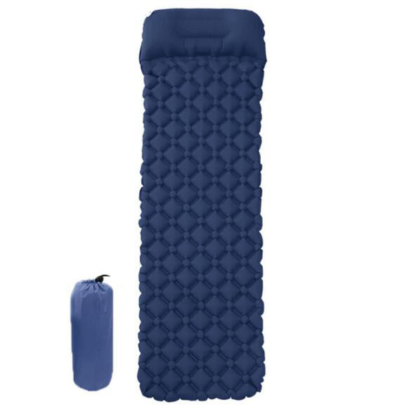 An inflated blue camping sleeping pad with a pillow section is shown next to its deflated and packed-down form in an orange stuff sack, both against a white background. The pad has a diamond-shaped air cell pattern.