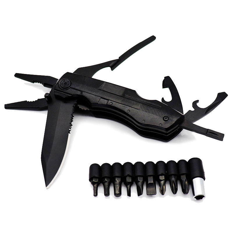 A black, folded multifunctional tool with pliers extended at the top left and a partially unfolded serrated knife blade visible on the left. Below the tool are nine black screwdriver bits arranged in a row, along with a silver magnetic bit holder.