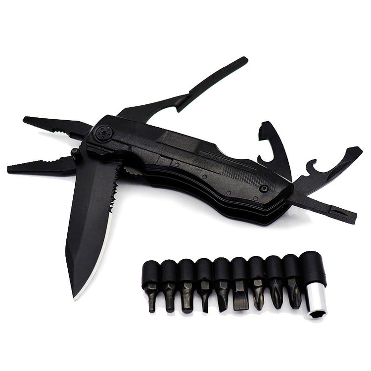 A black, folded multifunctional tool with pliers extended at the top left and a partially unfolded serrated knife blade visible on the left. Below the tool are nine black screwdriver bits arranged in a row, along with a silver magnetic bit holder.