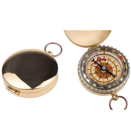 Two images of a small, round, golden brass pocket compass are shown against a white background. One image shows the compass closed, and the other shows it open, revealing the compass face with directional markings and a needle.