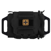 A black tactical first-aid pouch with MOLLE webbing and a Velcro patch featuring a tan medical cross is shown against a white background. The pouch has side loops for belt mounting and pull tabs for quick opening