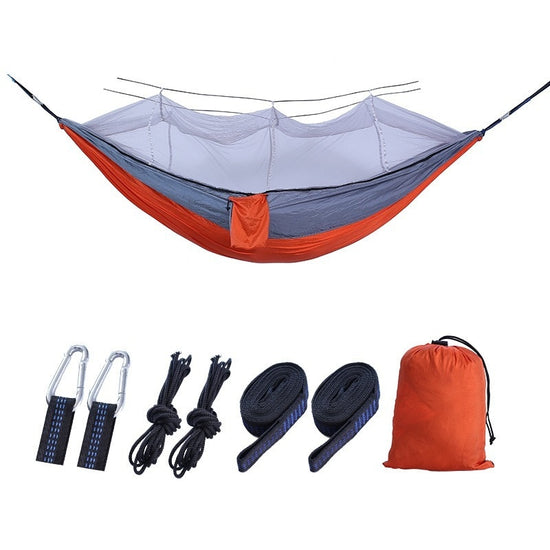 A double camping hammock made of dark green and fruit green fabric with a white mosquito net suspended above it is shown against a white background. The text "Dark green with fruit green + white mesh" is below the hammock.