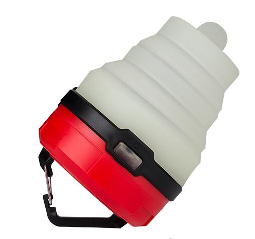 A compact, retractable LED camping lantern with a red base, black accents, and a white collapsible top is shown against a white background. A small hook is attached to the base.