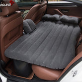 A gray OGLAND car inflatable travel mattress bed is shown inflated in the back seat of a car. A matching inflatable pillow rests on top of the mattress.