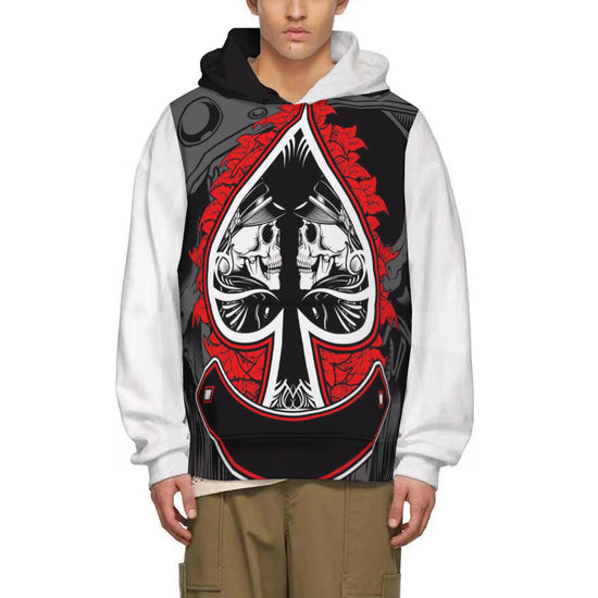 A man models a hoodie with a full-width print featuring a large black and white Ace of Spades outlined in red, incorporating detailed skeleton figures within the spade shape. Red leaf-like elements and grey mechanical or abstract designs surround the central graphic. The hoodie has a black hood, white sleeves, and a kangaroo pocket.